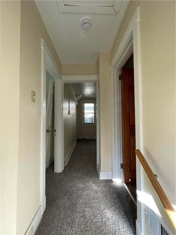 hallway with dark colored carpet