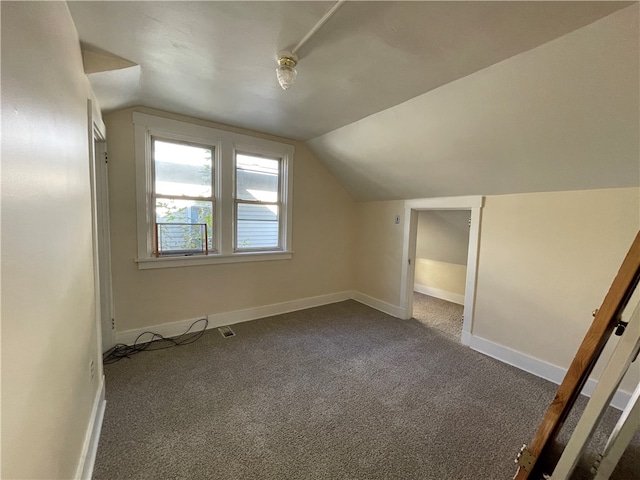 bonus room with vaulted ceiling and carpet