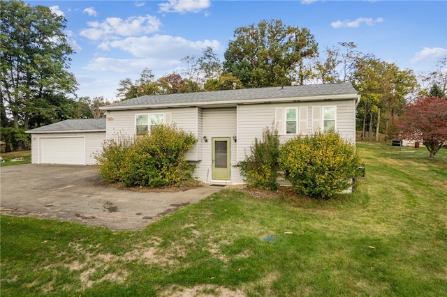 view of front of home featuring a garage, a front lawn, and an outbuilding