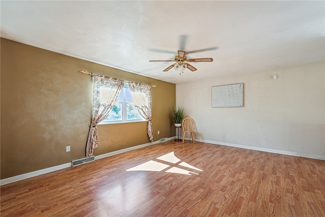 spare room with hardwood / wood-style floors and ceiling fan