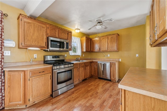 kitchen with stainless steel appliances, light hardwood / wood-style floors, beamed ceiling, sink, and ceiling fan