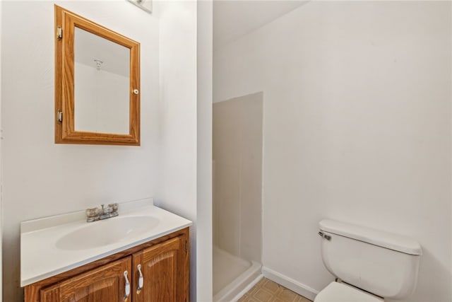 bathroom featuring walk in shower, vanity, and toilet