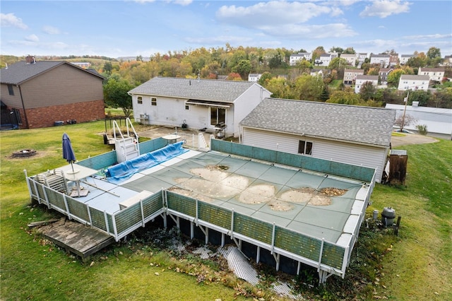 rear view of property featuring a yard and a pool side deck