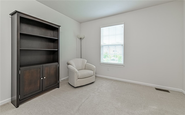 living area featuring light carpet