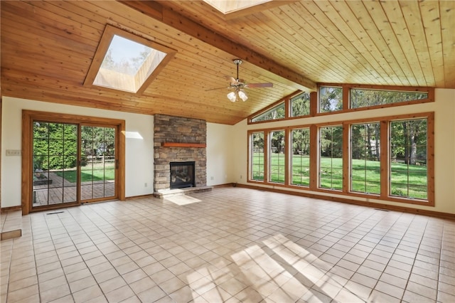 unfurnished living room with a skylight, a fireplace, beamed ceiling, and light tile patterned floors