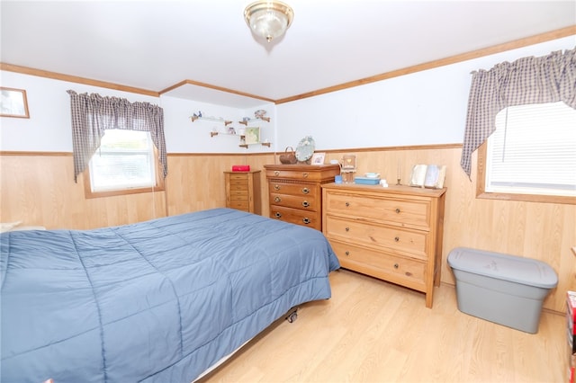 bedroom featuring crown molding, light wood-type flooring, and wood walls