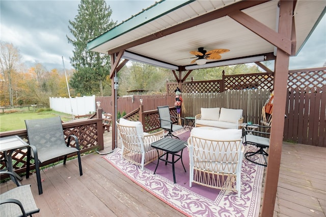 wooden deck with ceiling fan and an outdoor living space