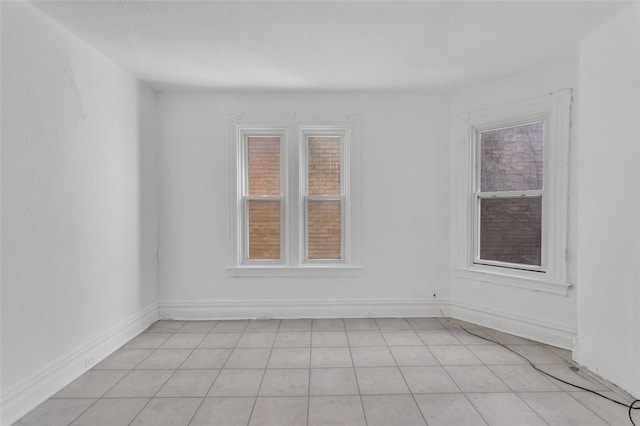 empty room with a wealth of natural light and light tile patterned floors