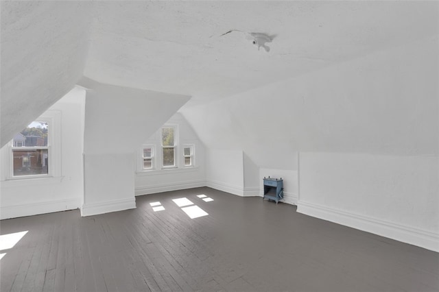 bonus room featuring dark wood-type flooring and vaulted ceiling