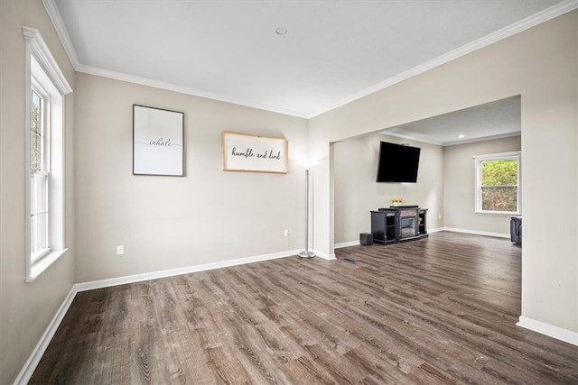 unfurnished living room featuring ornamental molding, hardwood / wood-style flooring, and a wood stove