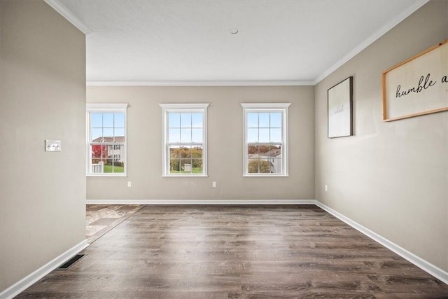 spare room with ornamental molding, plenty of natural light, and dark hardwood / wood-style flooring