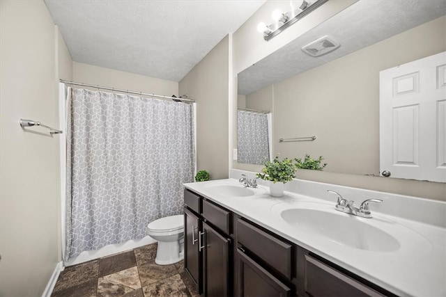 bathroom featuring vanity, toilet, a textured ceiling, and curtained shower