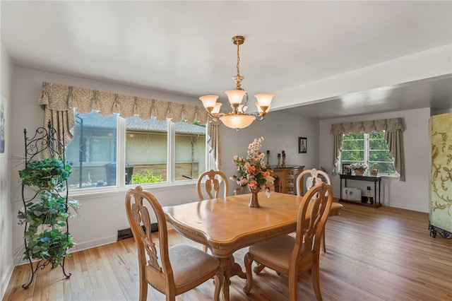 dining area with hardwood / wood-style floors and a chandelier