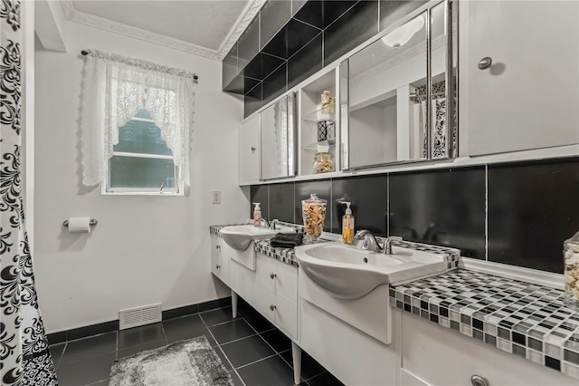 bathroom with vanity, crown molding, tasteful backsplash, and tile patterned flooring