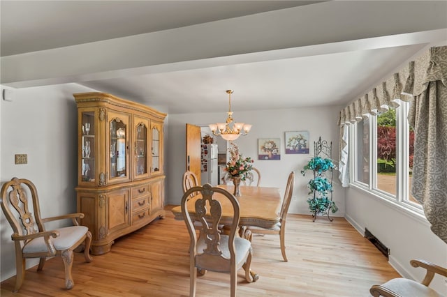 dining room with light hardwood / wood-style floors and an inviting chandelier