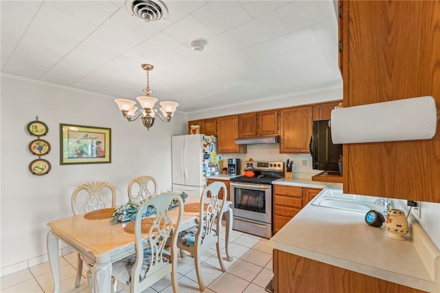 kitchen with white fridge, stainless steel electric range, pendant lighting, and light tile patterned floors