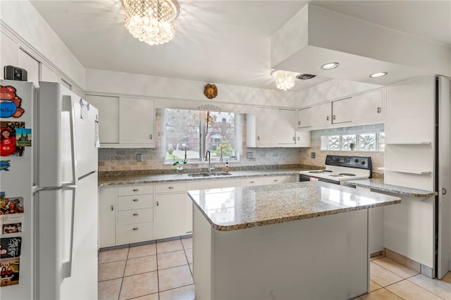 kitchen featuring white cabinetry, a center island, sink, and white appliances