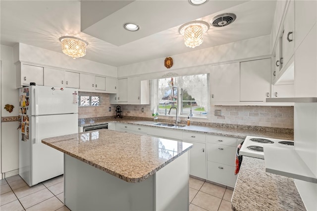 kitchen with sink, a center island, white cabinetry, a notable chandelier, and white refrigerator