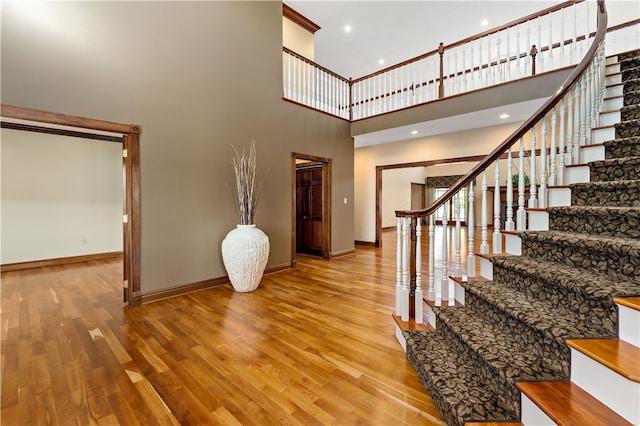 stairway featuring hardwood / wood-style flooring and a high ceiling