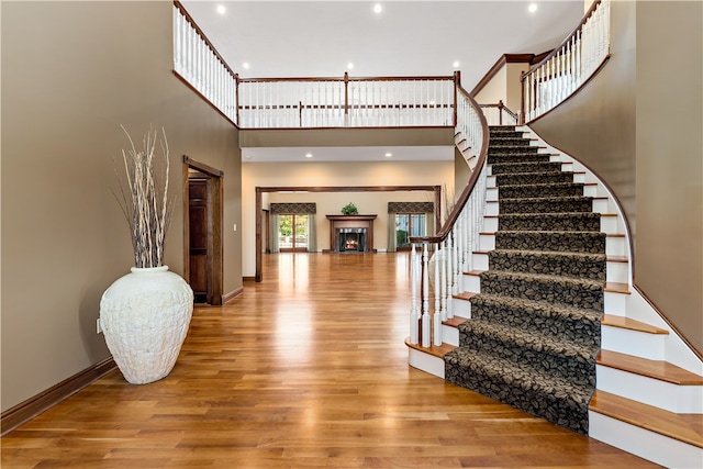 foyer entrance with a towering ceiling and hardwood / wood-style floors