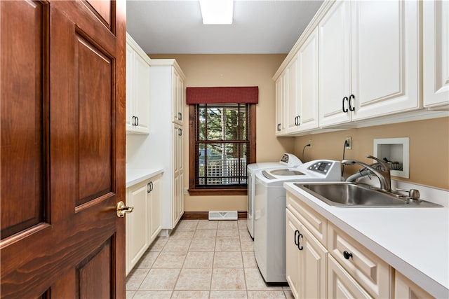 laundry area with sink, light tile patterned flooring, separate washer and dryer, and cabinets