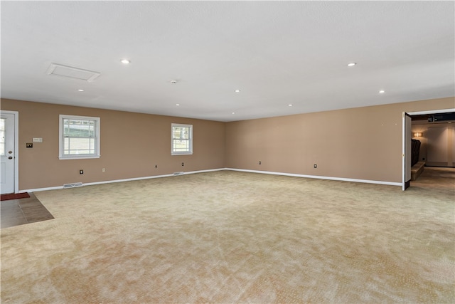 unfurnished living room featuring a wealth of natural light and light colored carpet