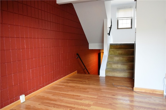 stairs with hardwood / wood-style flooring and vaulted ceiling