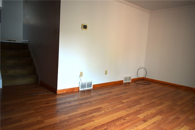 spare room featuring crown molding and wood-type flooring