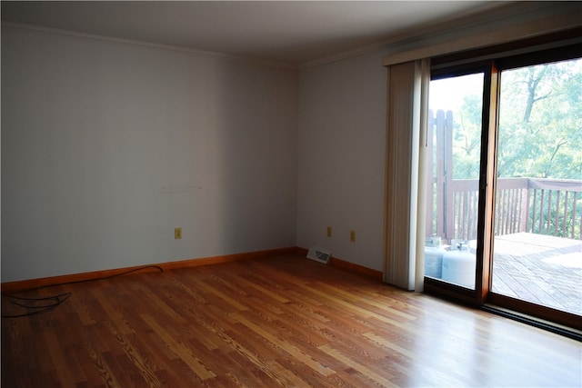 spare room featuring crown molding and light wood-type flooring