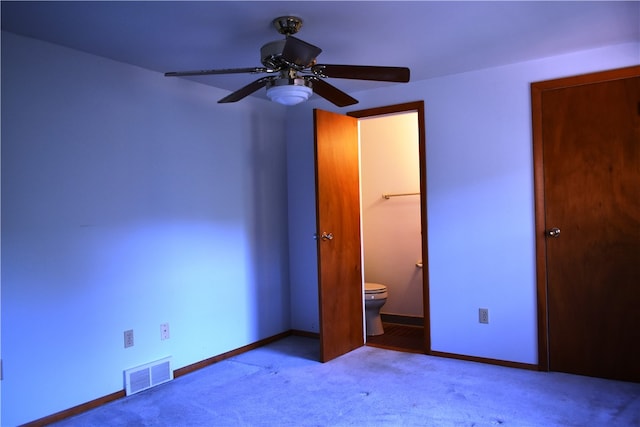 unfurnished bedroom with ensuite bath, light carpet, and ceiling fan