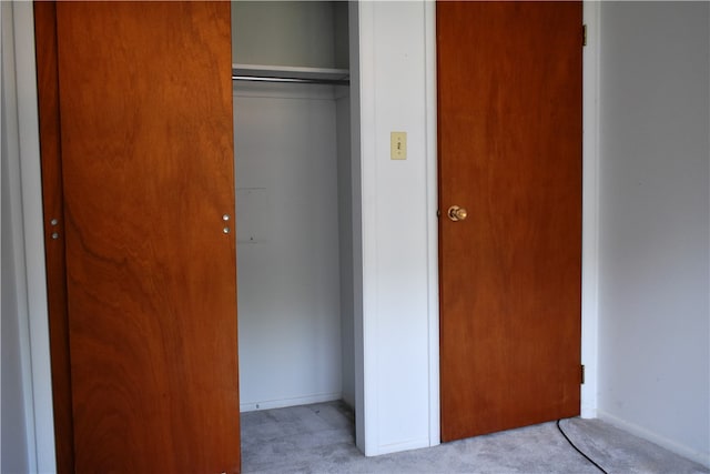 unfurnished bedroom with light carpet and a closet