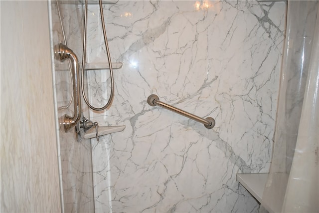 interior details featuring a tile shower