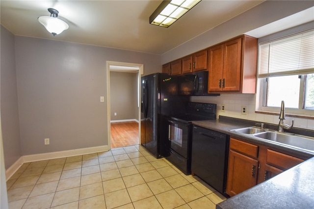 kitchen featuring light tile patterned floors, black appliances, sink, and backsplash