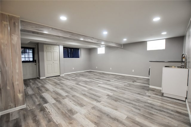 basement featuring sink and wood-type flooring