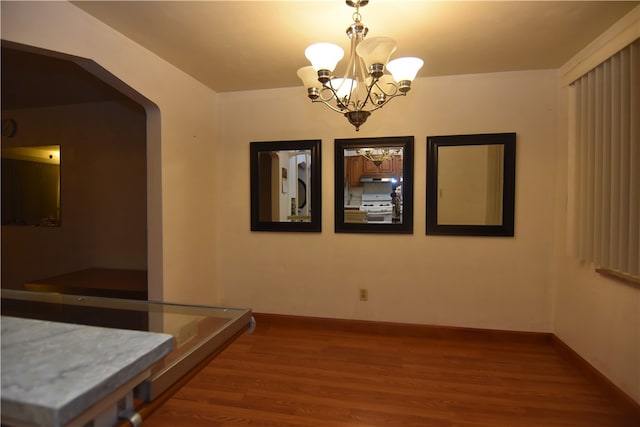 dining room with hardwood / wood-style floors and a notable chandelier