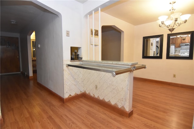 hallway with hardwood / wood-style floors and a notable chandelier