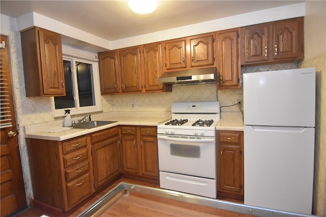 kitchen with white appliances, sink, and tasteful backsplash