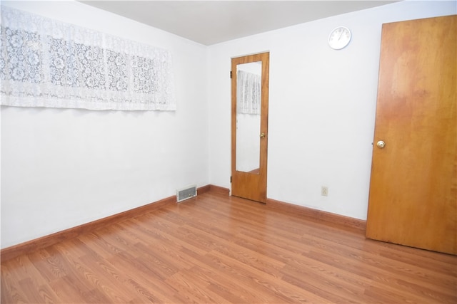 empty room with light hardwood / wood-style flooring