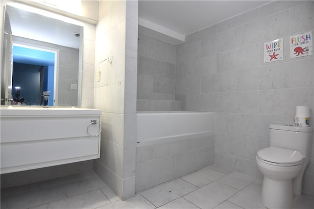 bathroom featuring vanity, toilet, and tile walls