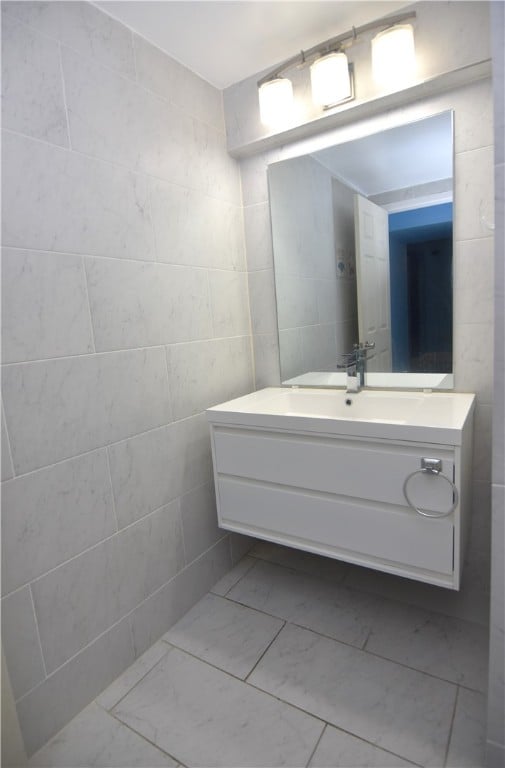 bathroom with vanity and tile walls