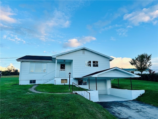 back of house with a garage, a lawn, and a carport