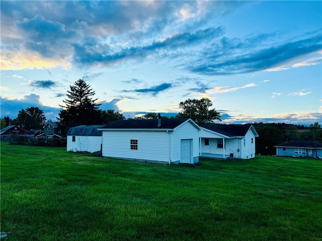 view of side of property with an outdoor structure and a lawn