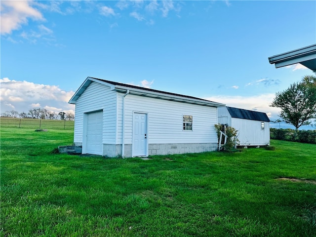 view of outdoor structure with a garage and a lawn