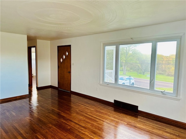 unfurnished room with dark hardwood / wood-style flooring