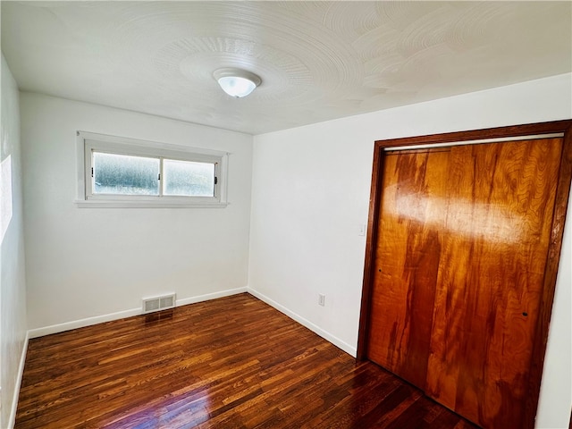 unfurnished bedroom featuring dark hardwood / wood-style flooring