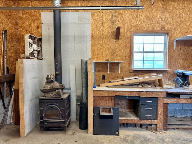 miscellaneous room featuring concrete floors and a wood stove