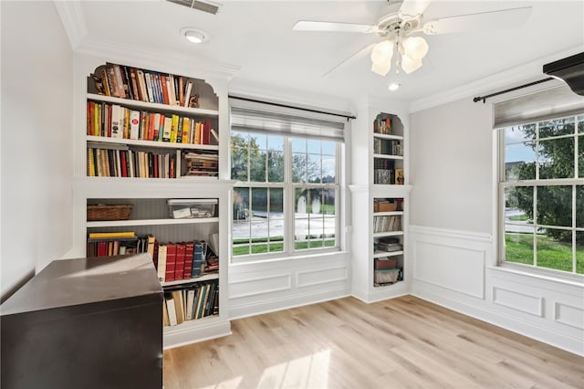 living area featuring ornamental molding, light wood-type flooring, and ceiling fan