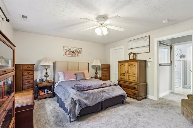 carpeted bedroom with a textured ceiling and ceiling fan