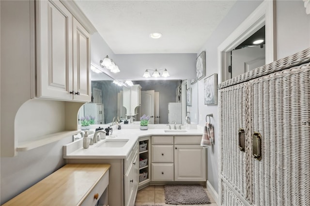 bathroom with vanity, a textured ceiling, and tile patterned flooring