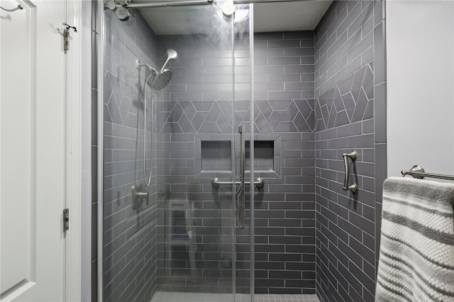 bathroom with a shower with door